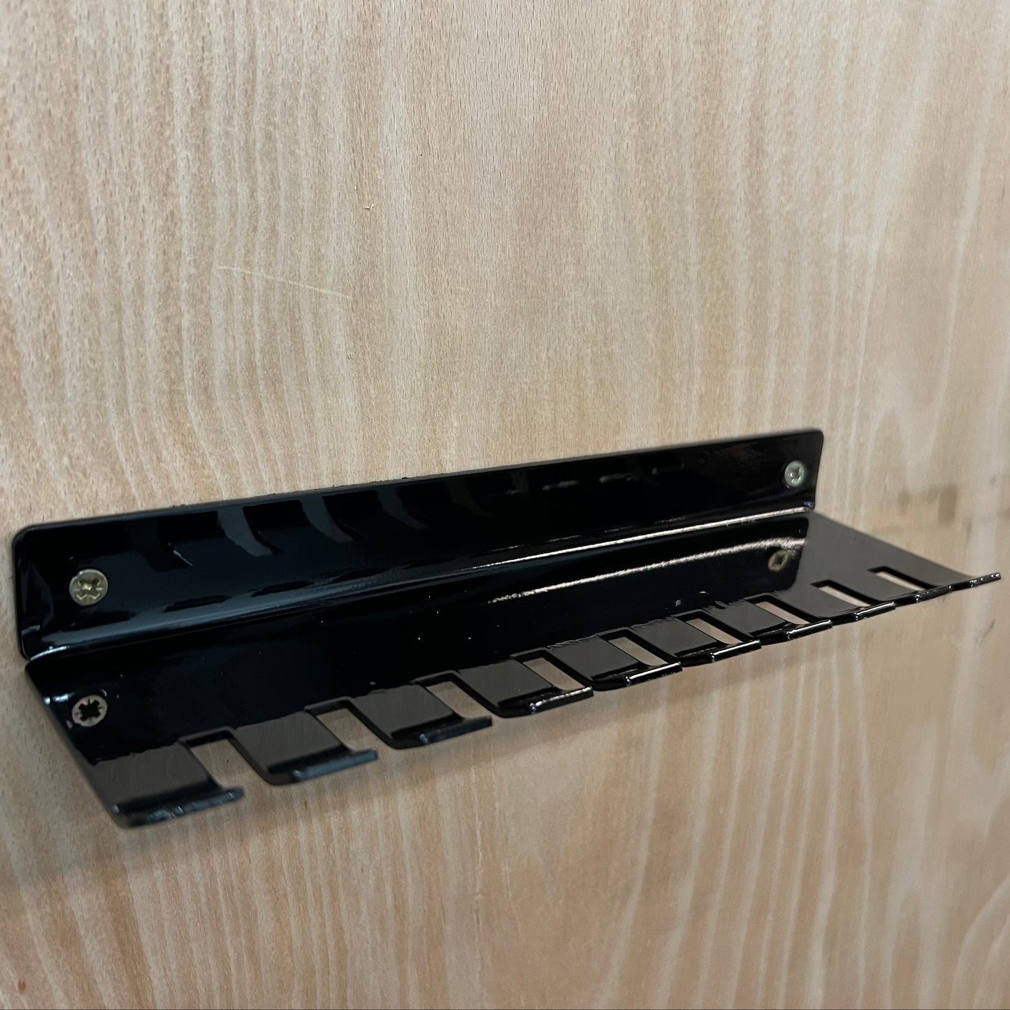 Black metal bracket on a wooden surface