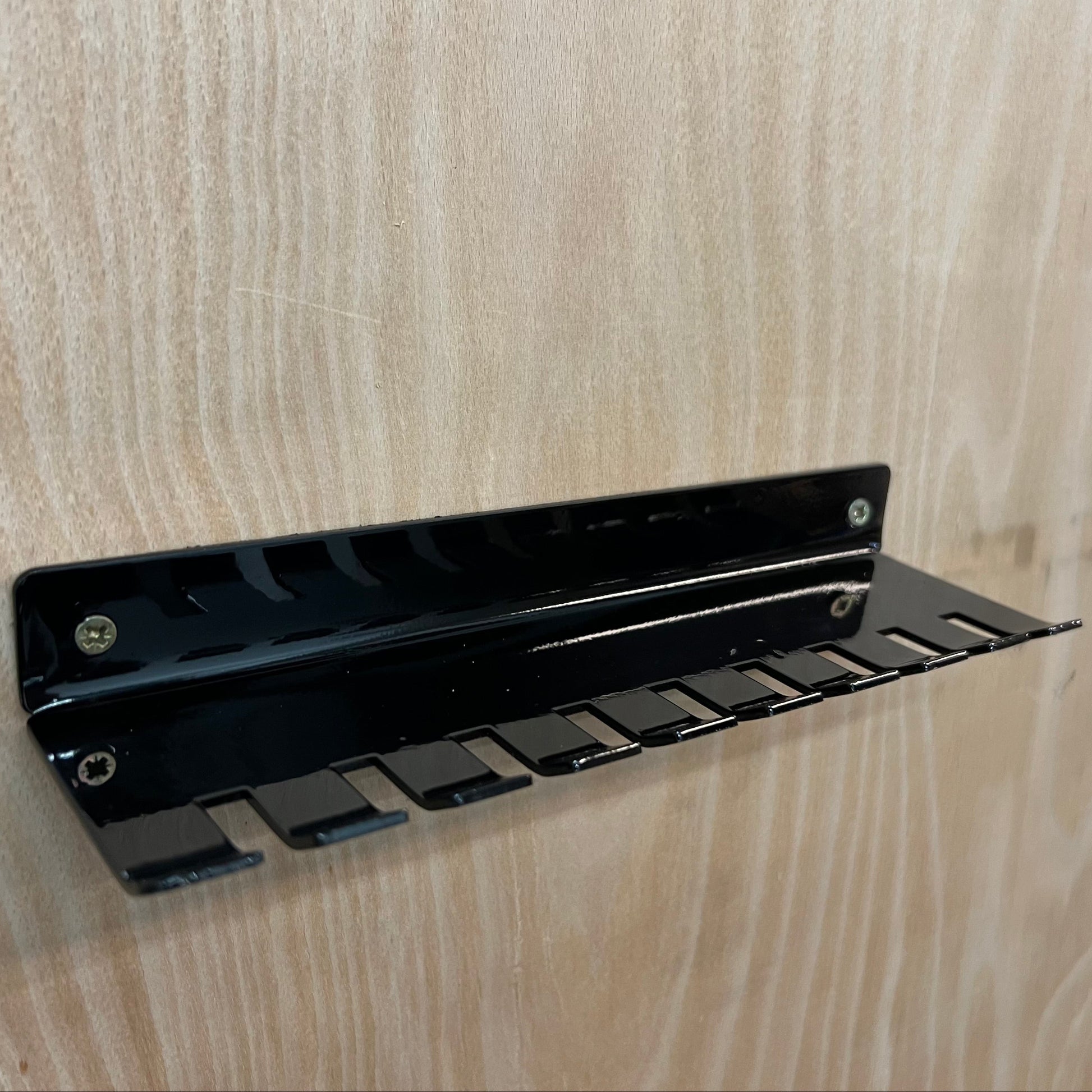 Black metal bracket on a wooden surface