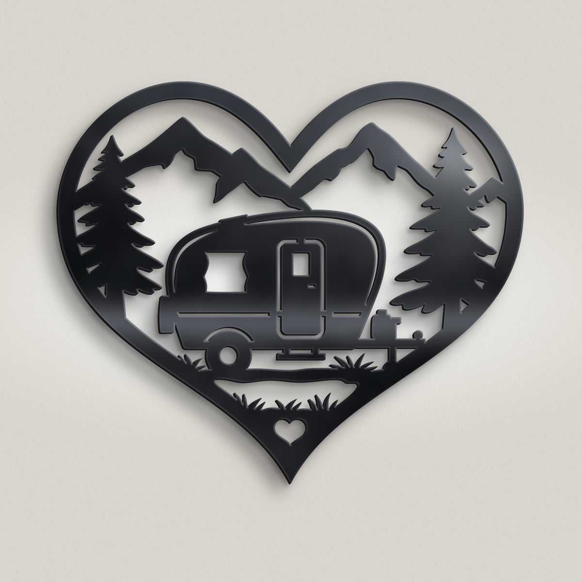 A black metal heart-shaped wall art piece featuring a silhouette of a vintage camper trailer, pine trees, mountains, and a small heart at the bottom, shown against a light gray background.